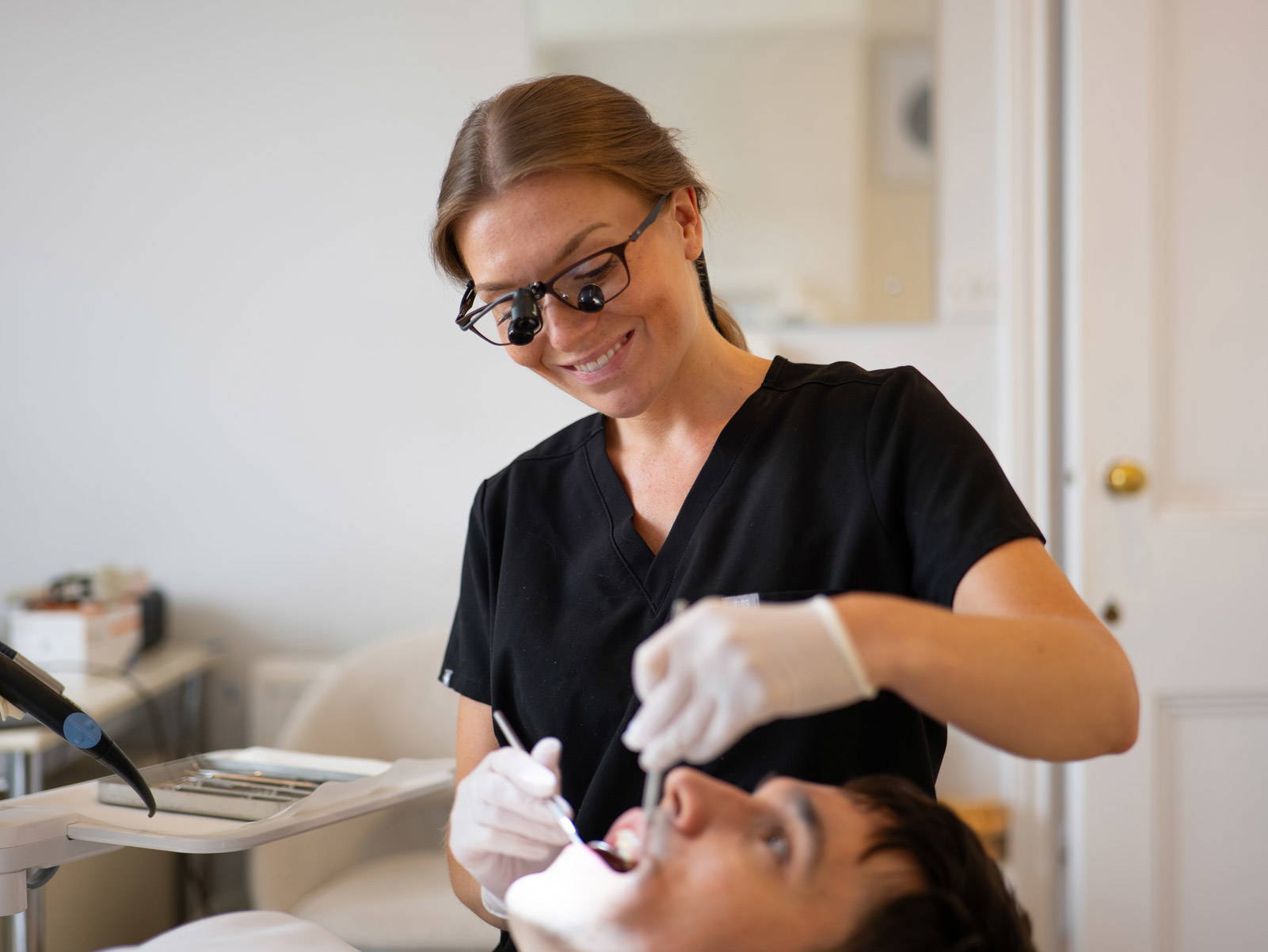 Dr Francesca Coulthard wearing dental loupes performs a routine check up on a new patient